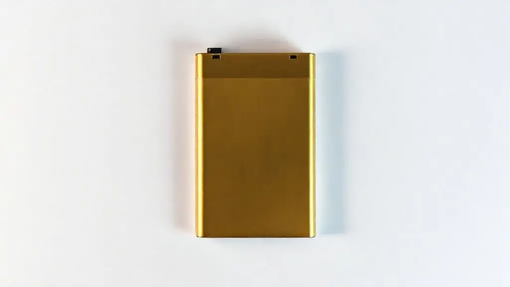 Fotografia profissional de uma bateria de substituição dourada para iPhone com alta capacidade, destacando o design premium e a textura metálica.